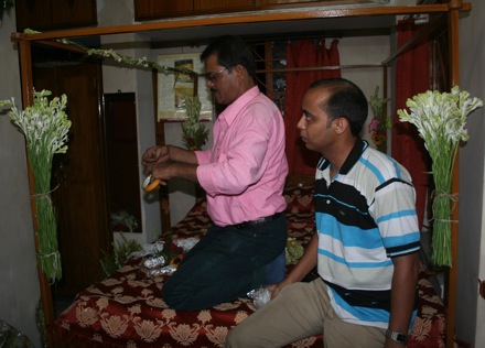 Preparing the bed decorated with flowers for the new couple on their first night together.